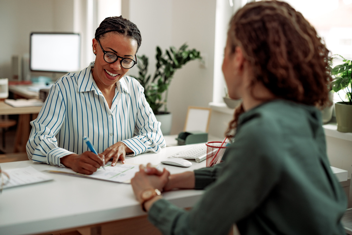 shot of 2 employees going through interview training for managers
